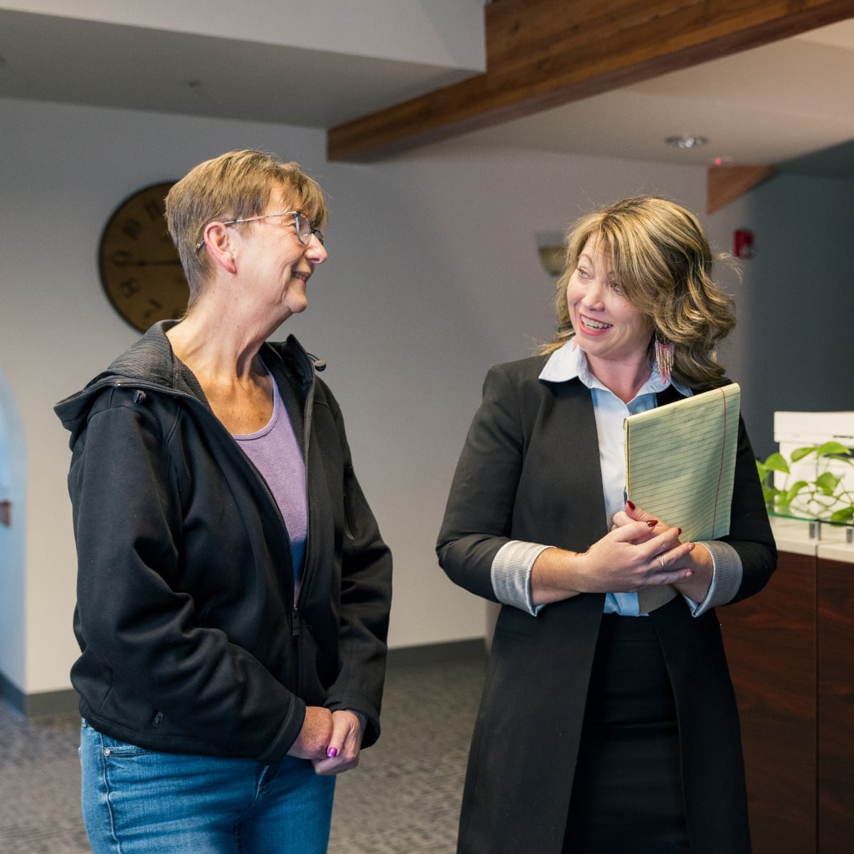 Jill Miller talking with a client at the front desk