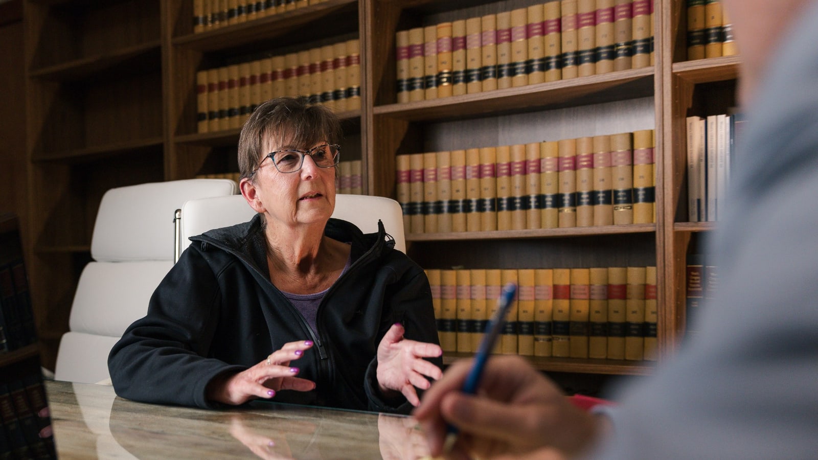 A client talking through her case at the table in the firm's law library
