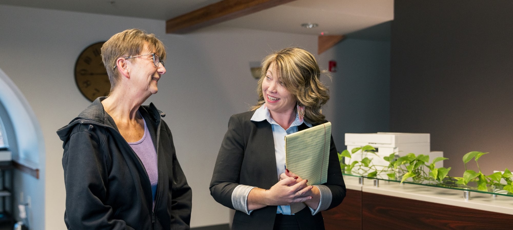 Jill Miller talking with a client at the front desk at Precision Litigation Northwest